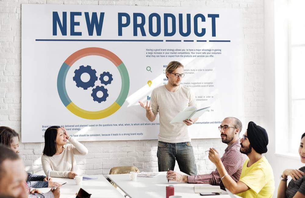 Man standing in front of new product plan presentation